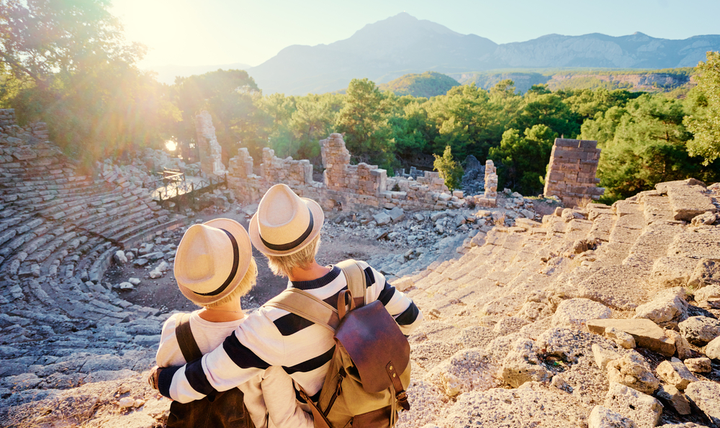A mature couple enjoying the view of an ancient amphitheatre.
