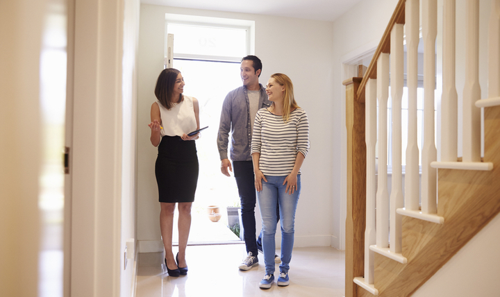 An estate agent showing a couple around an empty home.