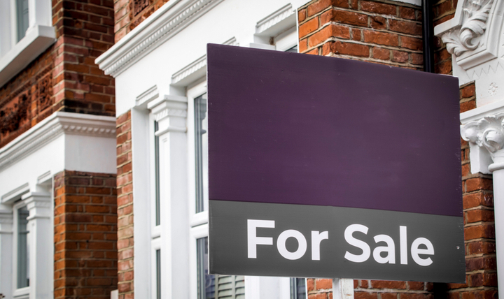A “for sale” sign outside of a house.