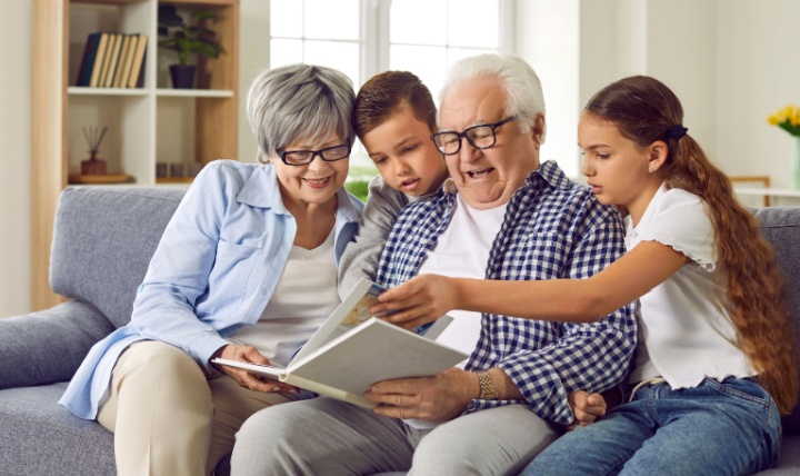 Grandparents looking at a photo album with their grandchildren.