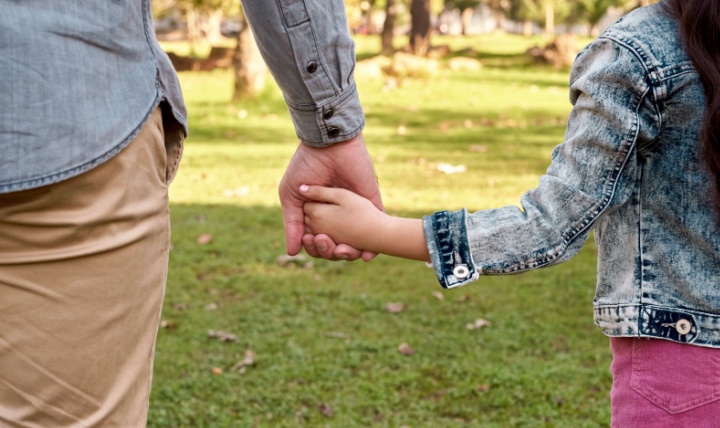 Parent and child holding hands.