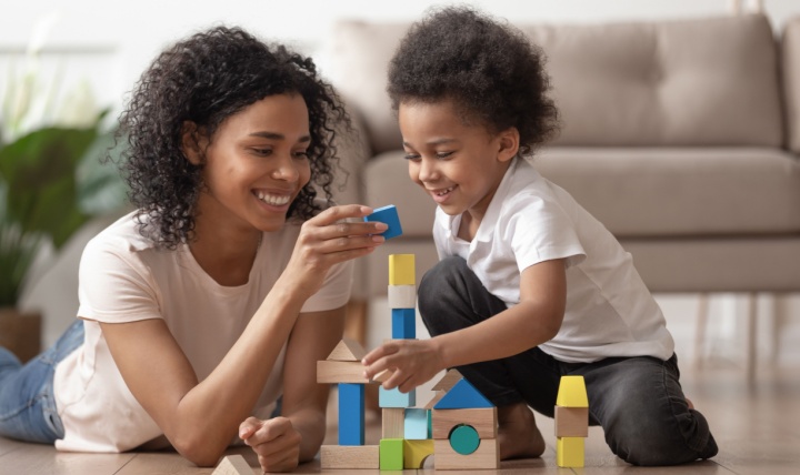 A mother and son building a tower from wooden blocks