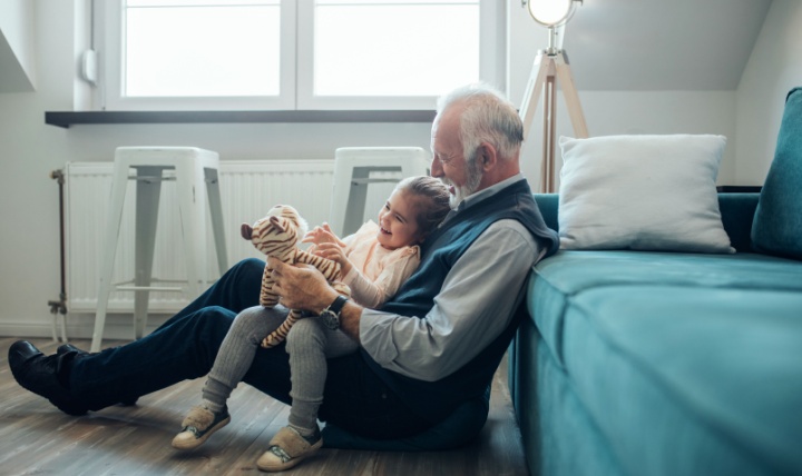 A grandfather playing with his granddaughter.