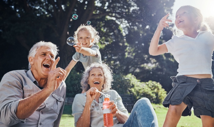 Grandparents blowing bubbles with their grandchildren.