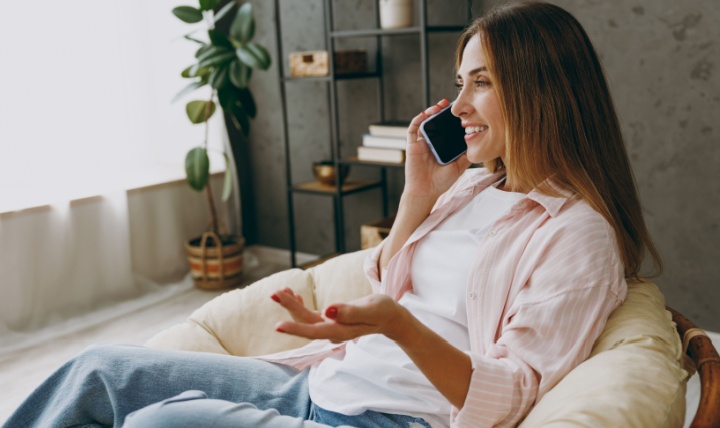 A woman talking on the phone at home.