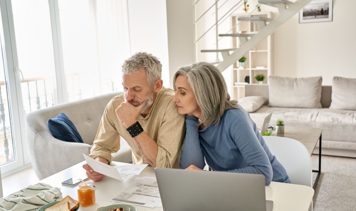 A couple looking at paperwork together in their home.