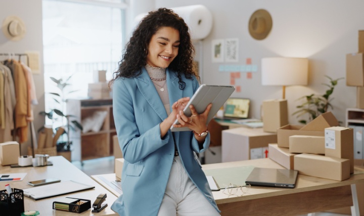 A female business owner using a tablet in an office.