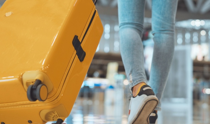 A woman pulling a suitcase through an airport.