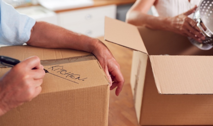 A close-up of a couple packing boxes to move home.