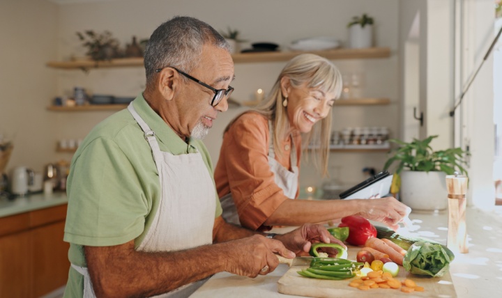 A couple cooking a meal together.