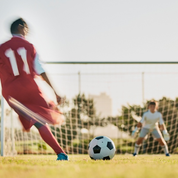 A footballer taking a shot at a goal.
