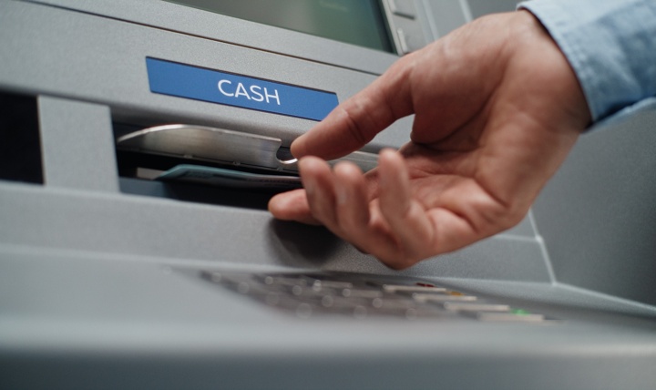 A person using an ATM to withdraw cash.