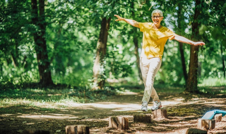 A woman doing balancing exercises outdoors.