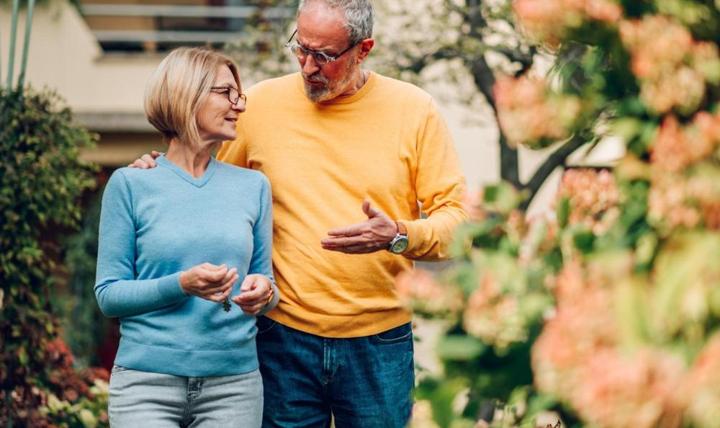 Mature couple walking outside a house