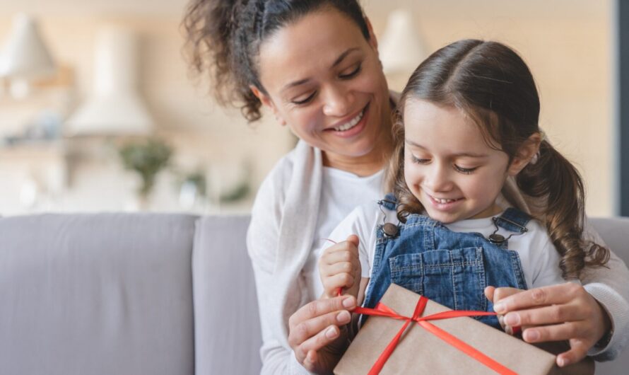 A mother and daughter unwrapping a gift.